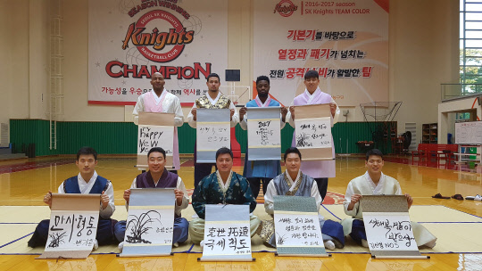 SK 나이츠 선수들이 28일 고양 오리온과의 홈 경기에서 팬들에게 나눠줄 친필 신년 덕담 족자를 들고 있다. 사진=SK 나이츠 제공